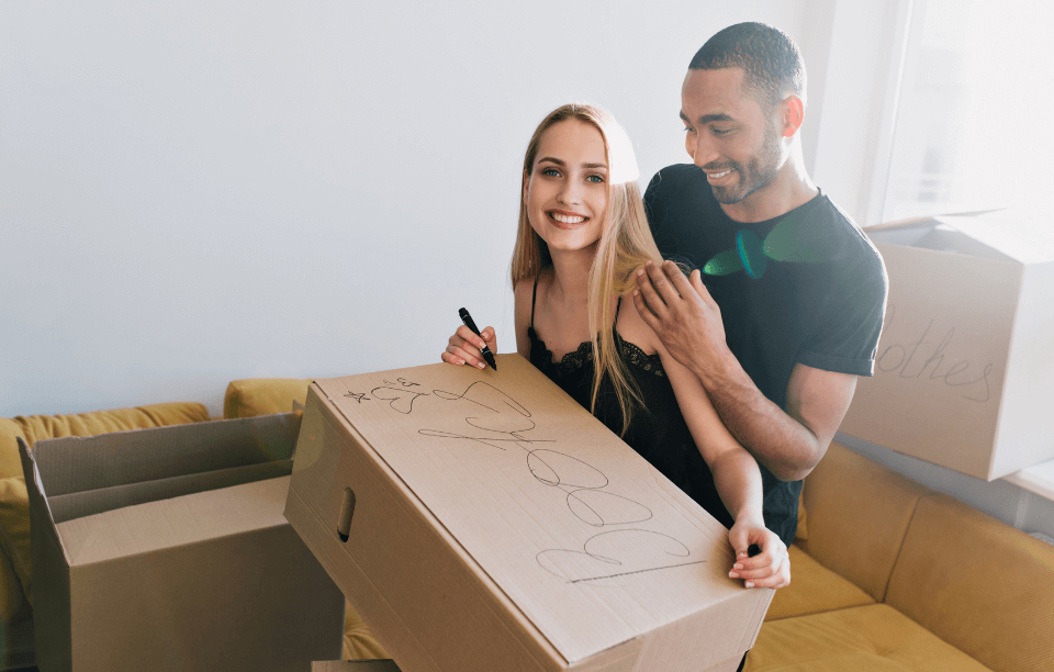 rental improvement ideas for landlords image: young, smiling couple with moving boxes