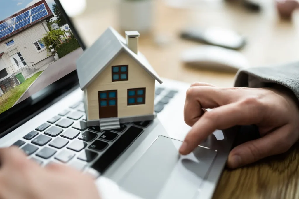 Property management and accounting software visualized with miniature house on a laptop and property image on screen.