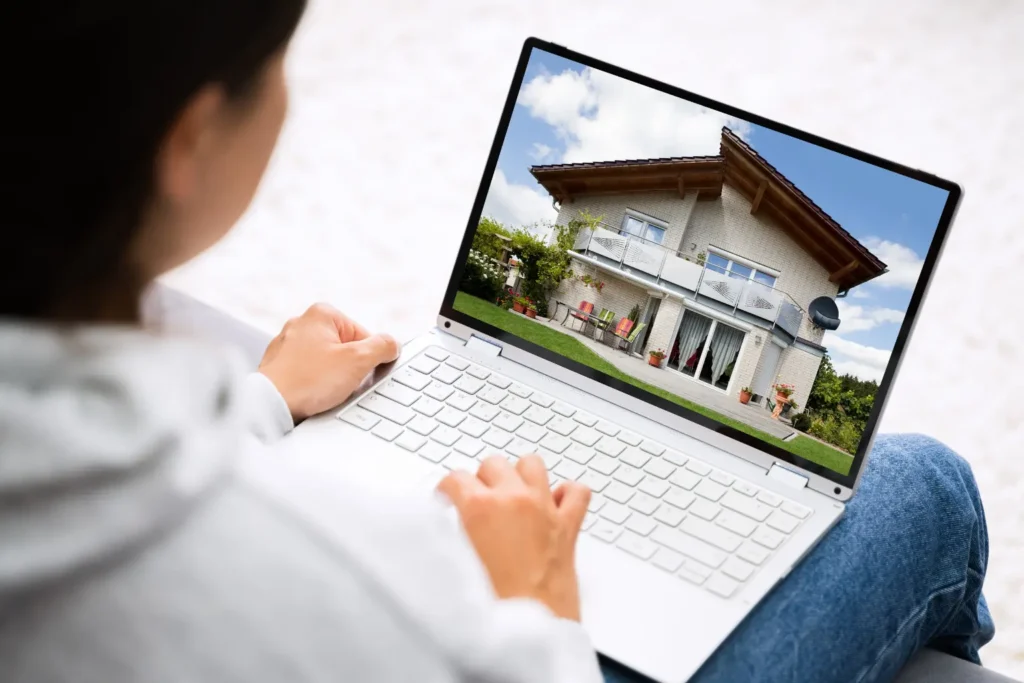 accounting software for property management on a laptop screen displaying a house listing photo