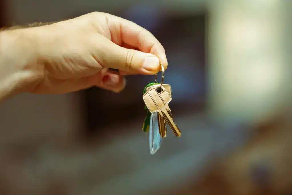 rental property owners receiving a set of house keys in a close-up handoff