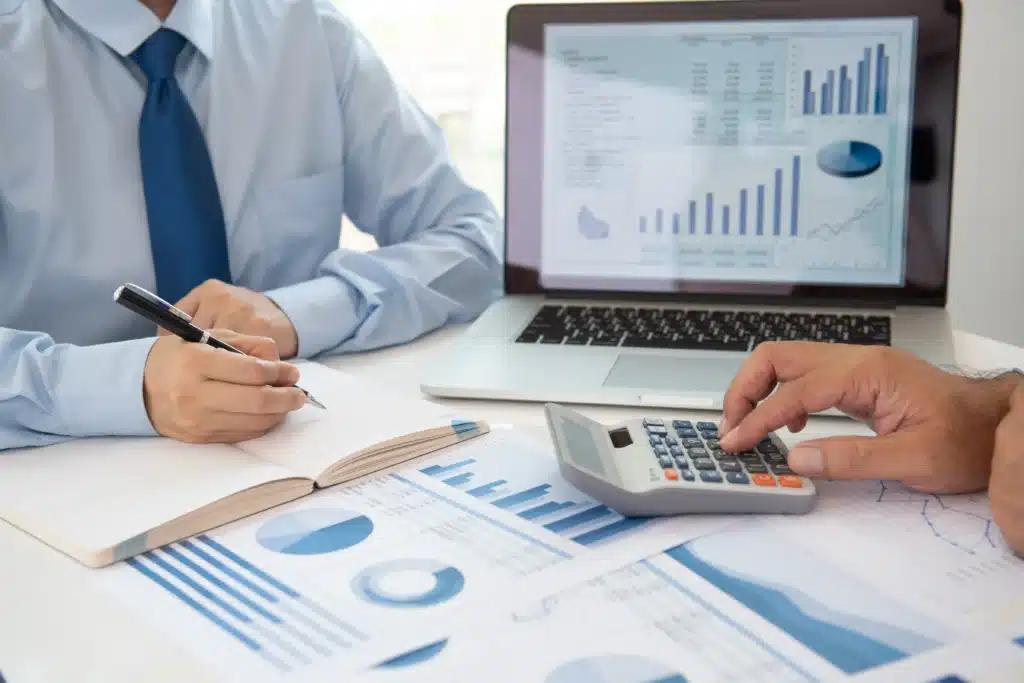 Best accounting software for property management displayed during financial review with laptop, calculator, and charts.