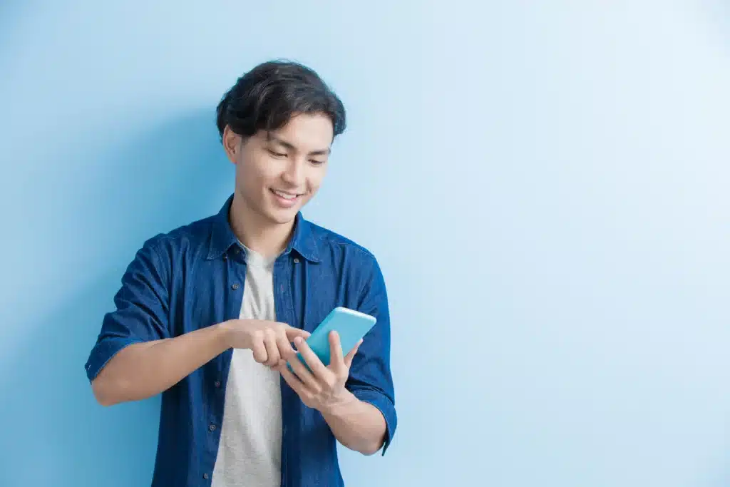 Property management software for landlords used on mobile phone by smiling user against clean blue background.