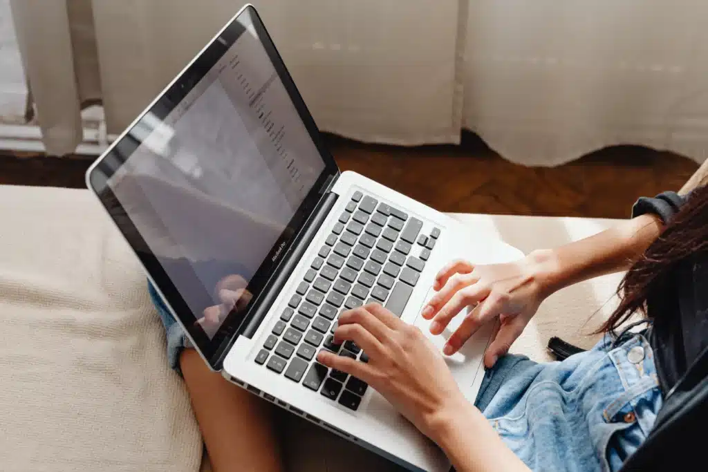 Rental property accounting software concept with user entering financial data on laptop at home workspace.