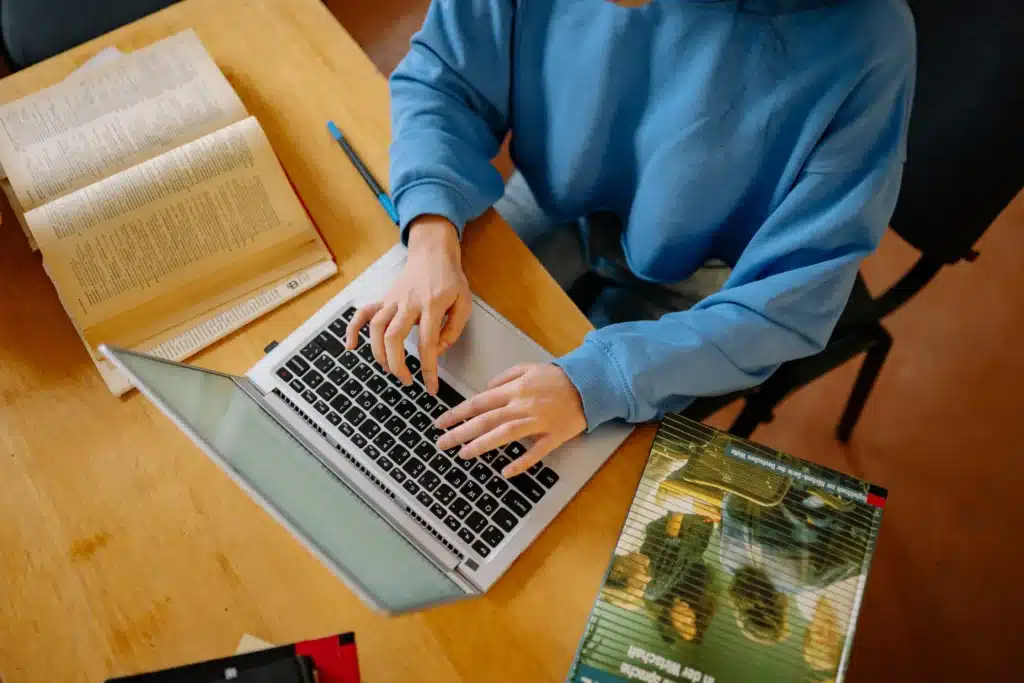 Find rent collection software online by comparing options on a laptop while reviewing rental management tools.