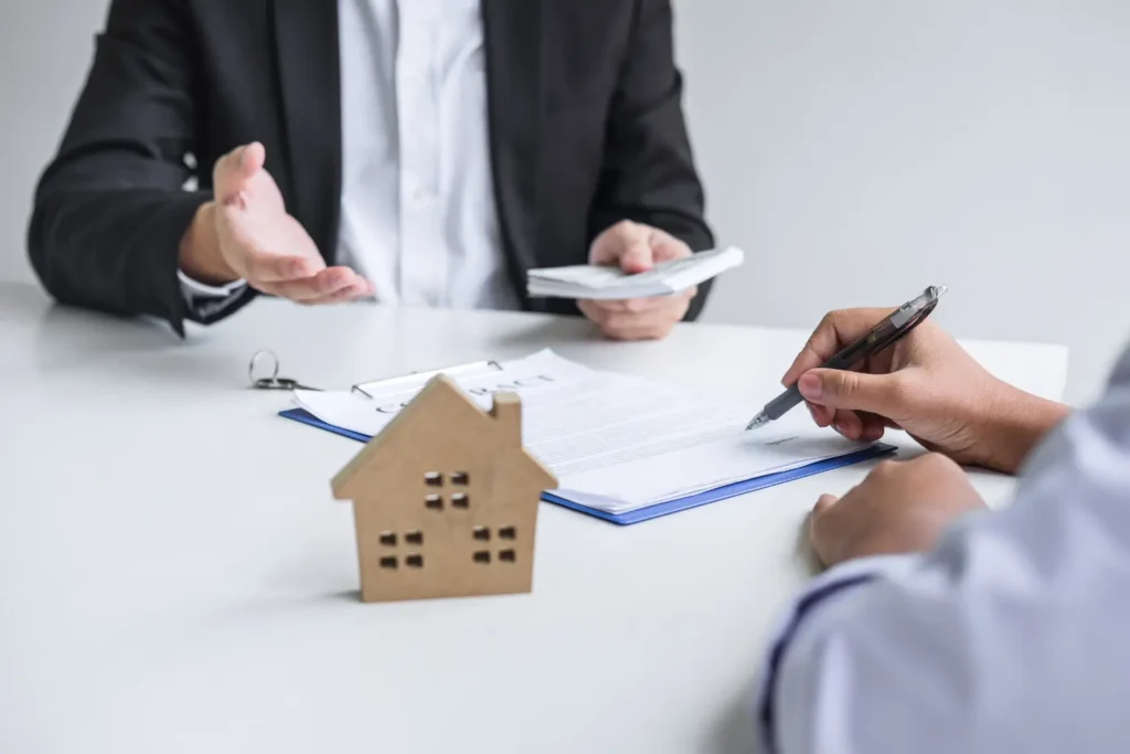 Mileage log for landlords supported by proper lease documentation as a tenant signs a rental agreement across from a property manager with a house model on the table
