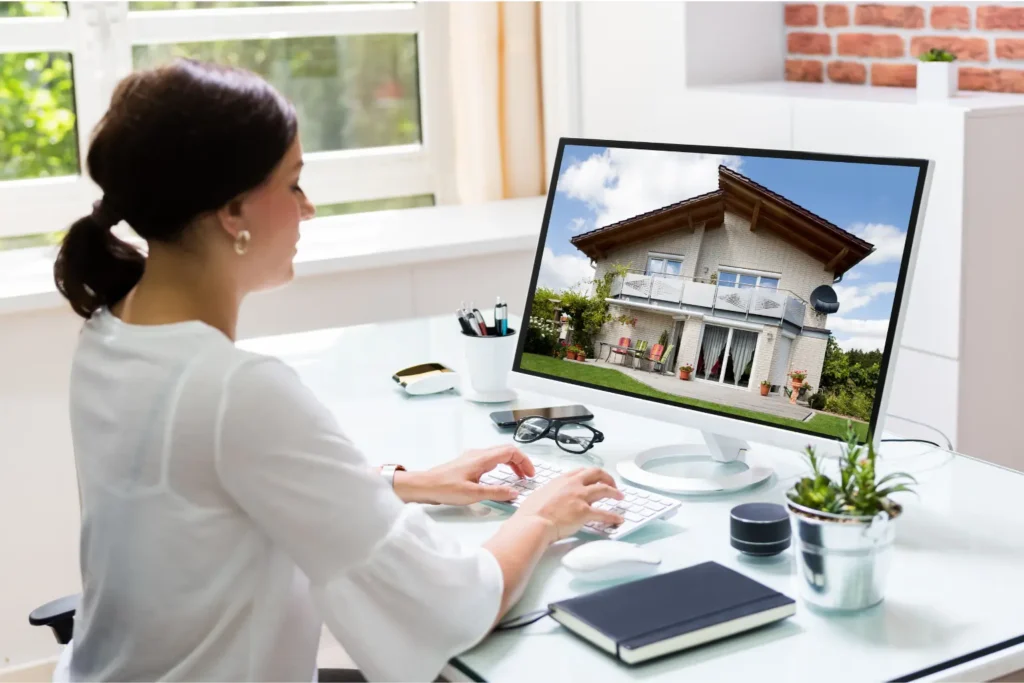 Online rent payment apps displayed on desktop monitor showing house listing in home office.