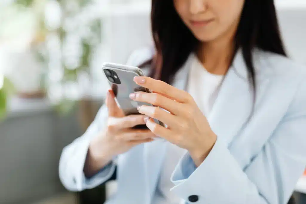 Property management app for landlords shown as a professional woman using a smartphone to manage rental tasks on the go.