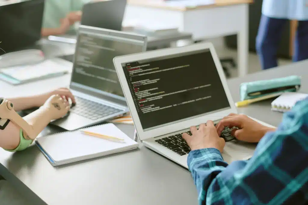 developers coding maintenance property management software on laptops in a classroom setting