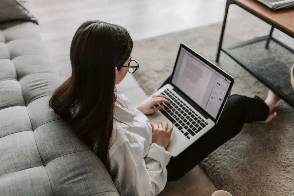 woman with glasses working on online property management software from home on laptop