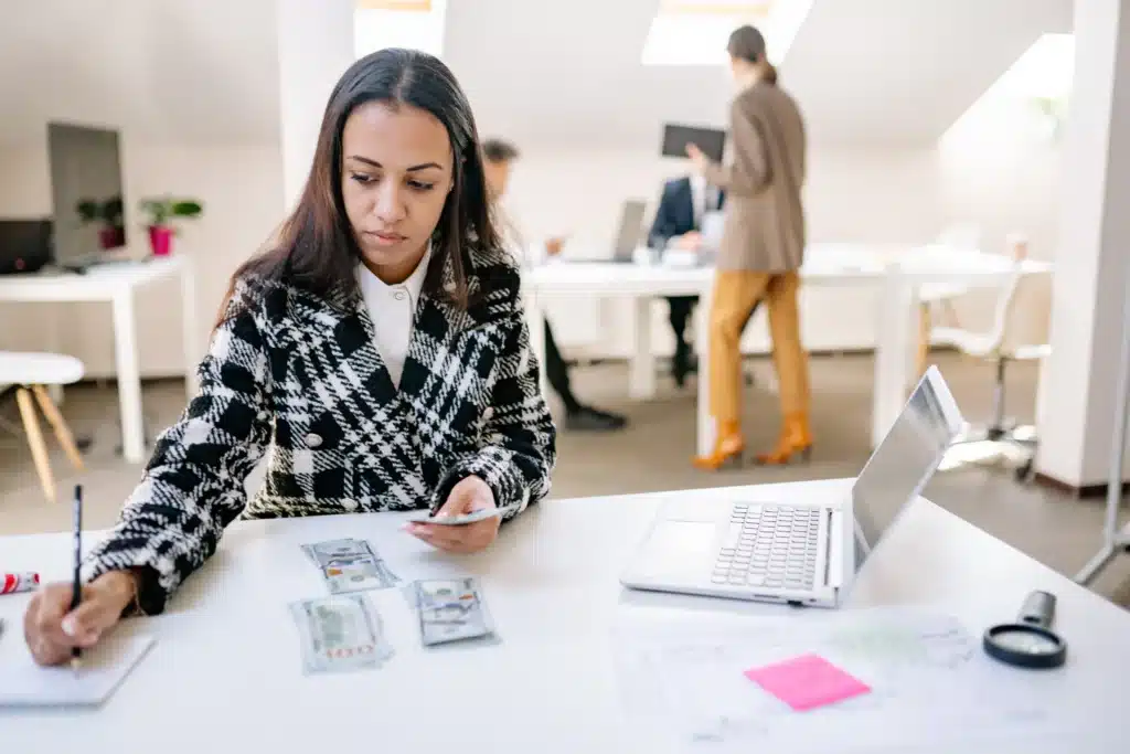property manager counting cash for real estate property management collection at office desk