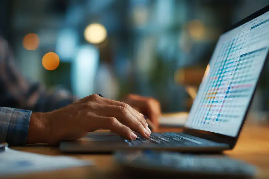 hands typing on laptop with rental accounting software spreadsheet on screen