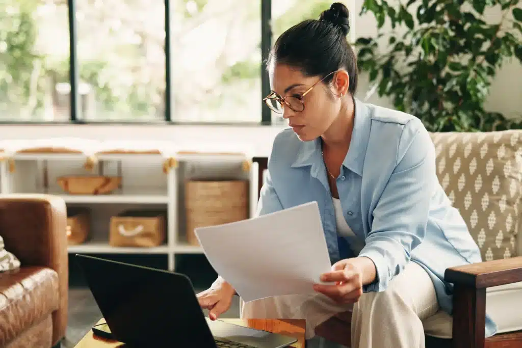 woman reviewing rental property maintenance documents on laptop at home